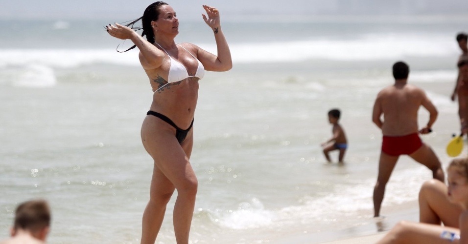 1.dez.2012 - A ex-modelo Cristina Mortágua foi à praia da Barra da Tijuca, na Zona Oeste do Rio de Janeiro. A ex de Edmundo não quis ficar com marquinhas e se bronzeou sem a parte de cima do biquíni, mas acabou deixando um pouco do seio à mostra ao dar um mergulho
